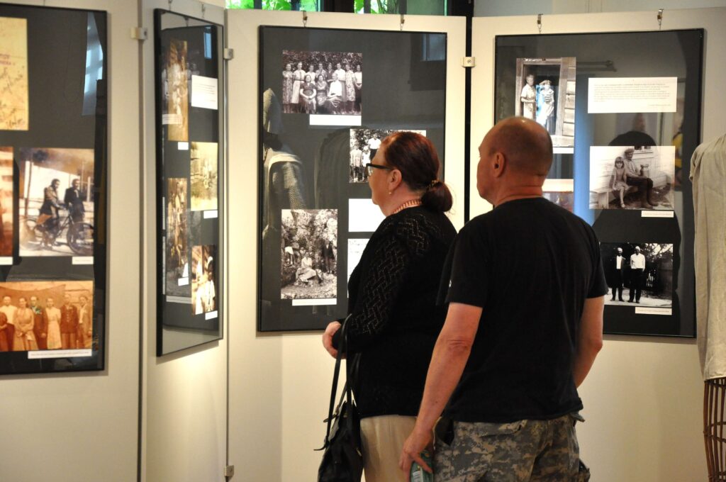 Kobieta i mężczyzna oglądają zdjęcia wiszące na ścianie.