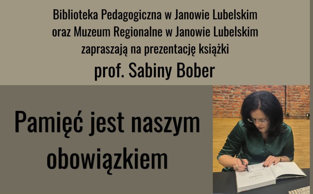 Kobieta z ciemnymi włosami i okularami podpisuje książkę przy stole, w tle czerwona ceglana ściana.